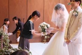 手袋をはめて挙式の間一時フラワーブーケを預かります