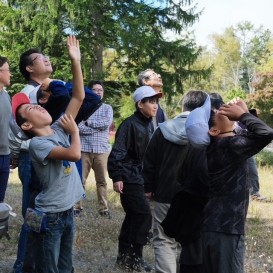 空高く上るドローンを見失わないように指で追いかけます